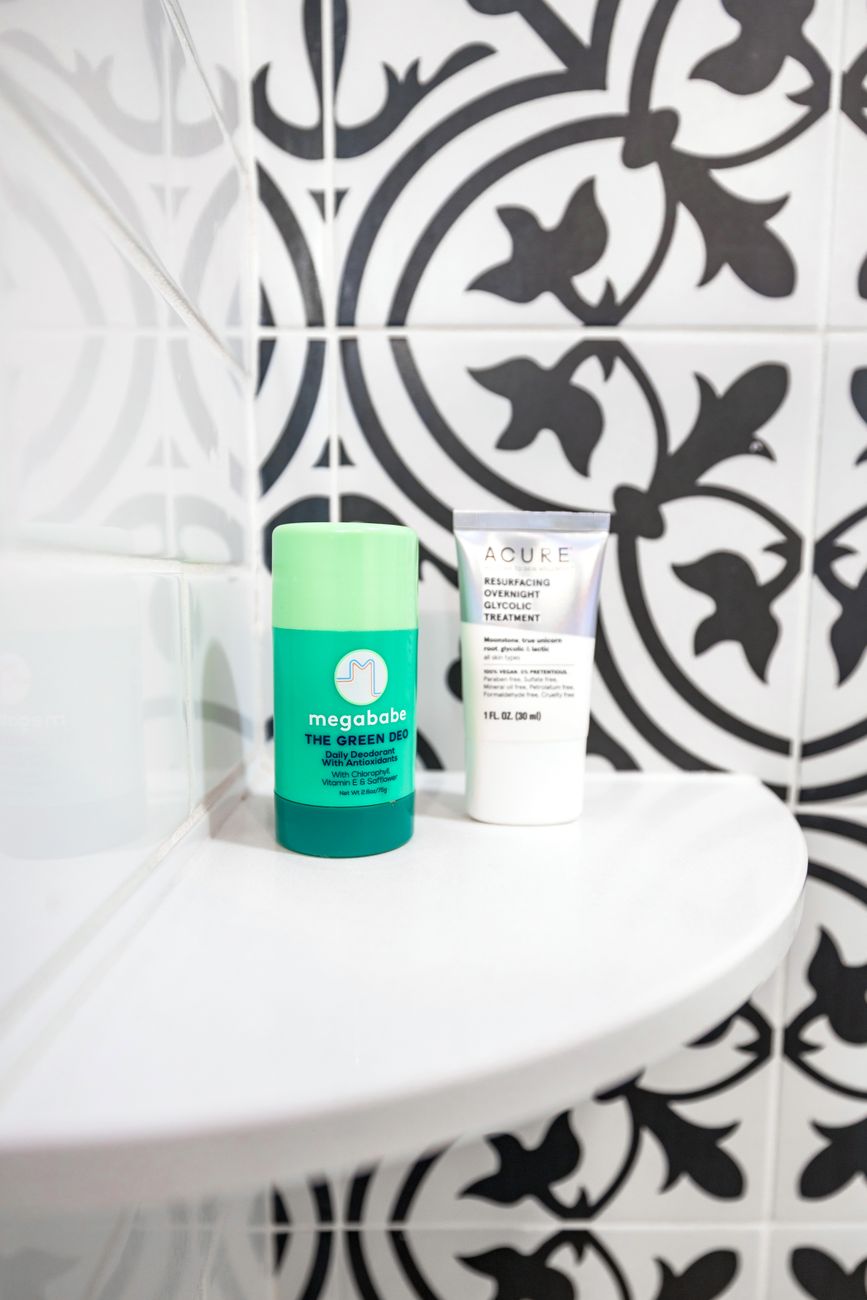 Skincare bottles arranged on a tiled bathroom shelf — a specimen row filed by ingredient panel.