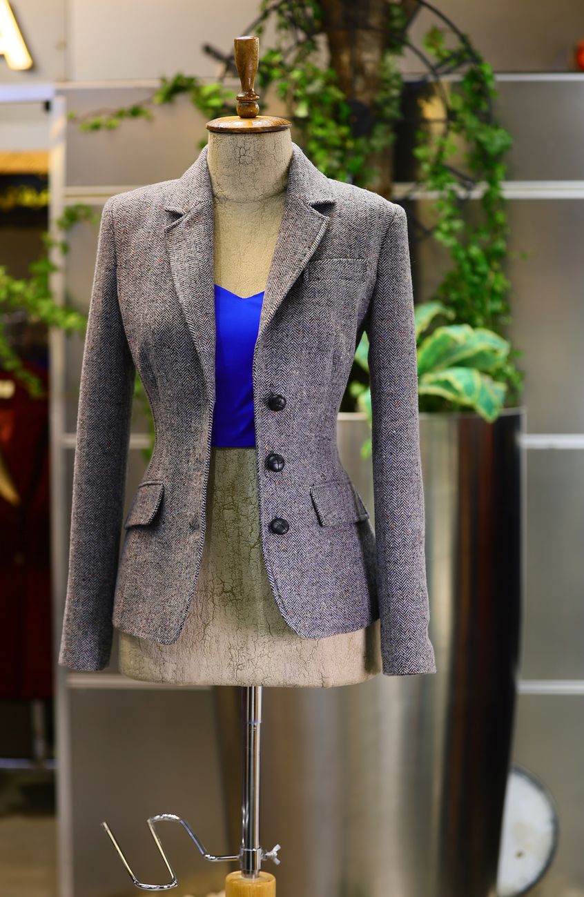 A tailored gray blazer on a vintage mannequin — the specimen view of a heritage garment.