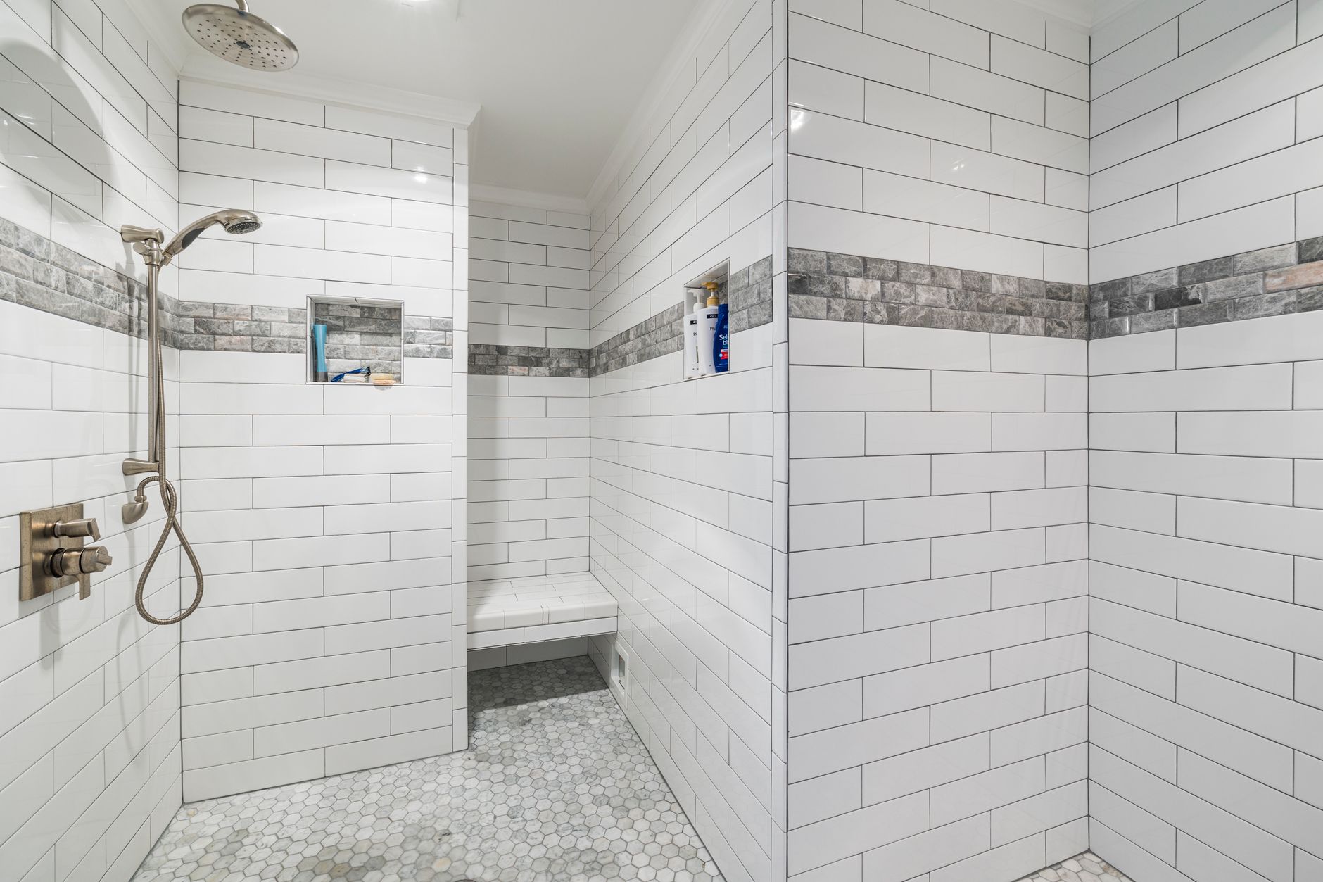 A minimalist white-tiled walk-in shower with modern chrome fixtures — the specimen view of a dual shower head system filed by flow rate and valve architecture.