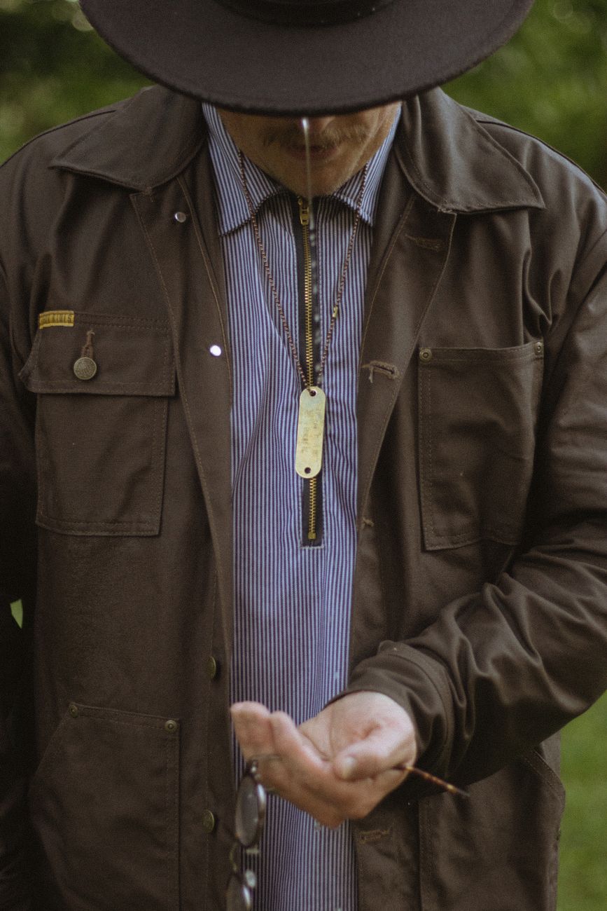 A man in a heavyweight wool workwear jacket standing outdoors in cold light — the Filson Cruiser silhouette worn in the field it was cut for.