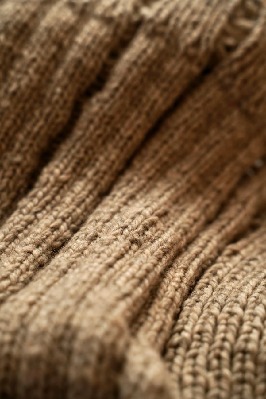 Macro-scale view of dense beige mackinaw wool fabric — the tight mill and short pile that make the Cruiser cloth what it is.
