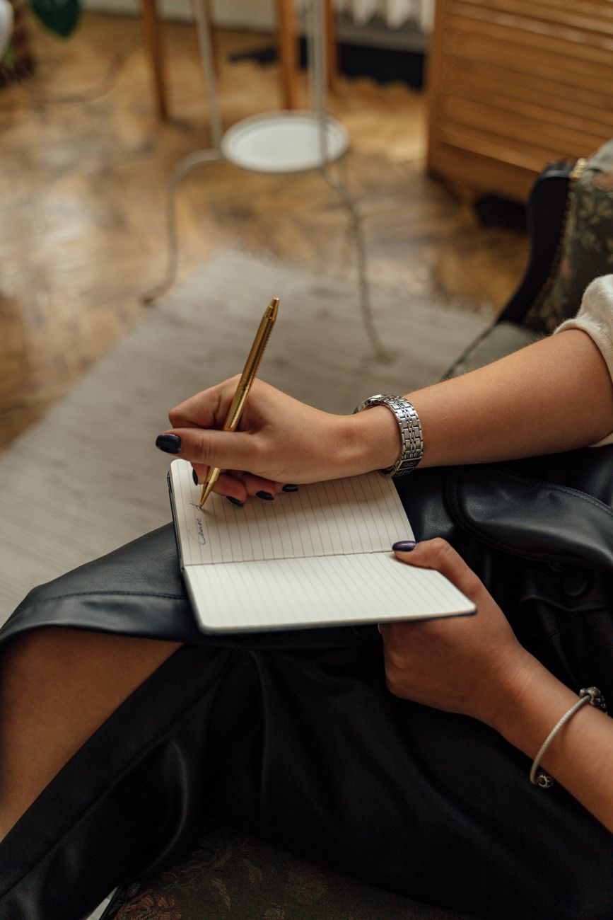 Hands writing in a leather notebook with a fountain pen — the daily use that determines whether an entry earns a place in the file.